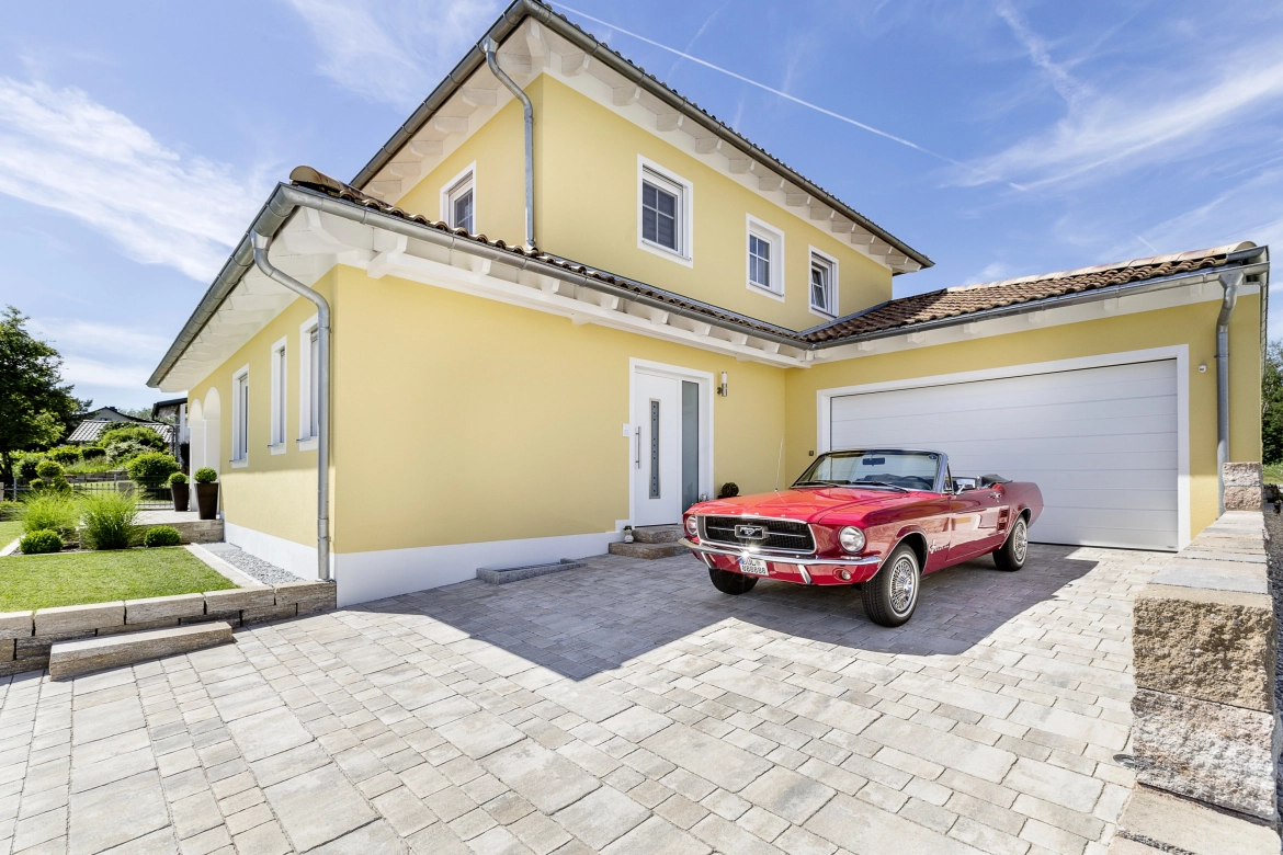 Mediterranean yellow house with a naturally paved driveway 