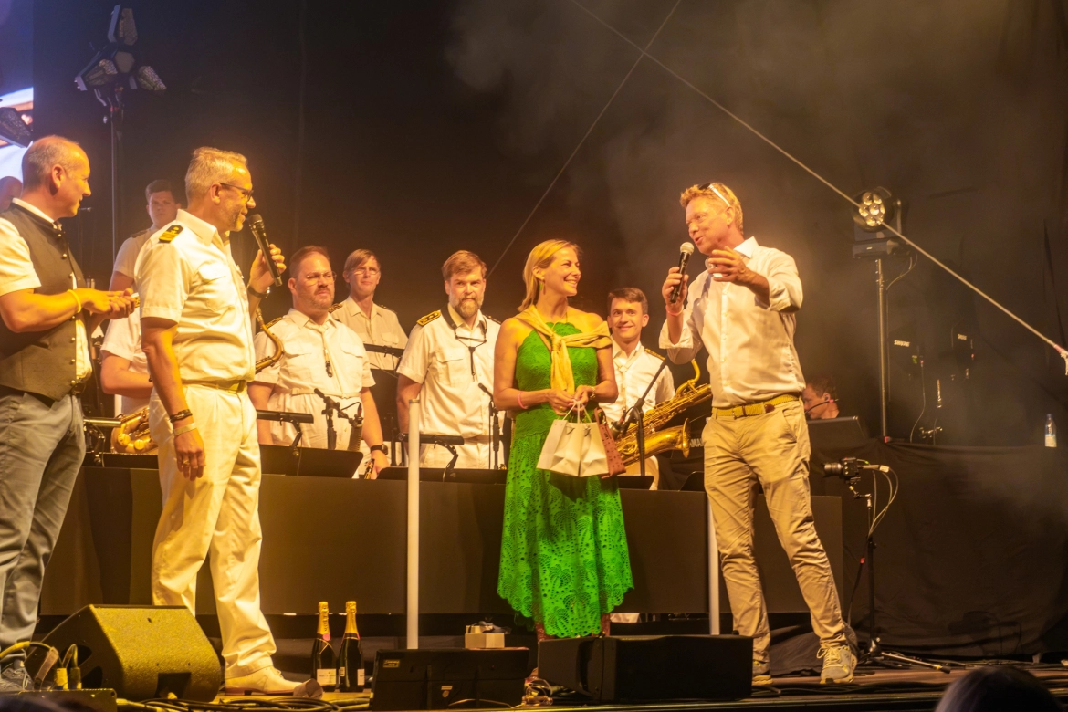 Bernd und Silvia Godelmann zusammen mit dem Moderator der BigBand der Bundeswehr auf der Bühne.