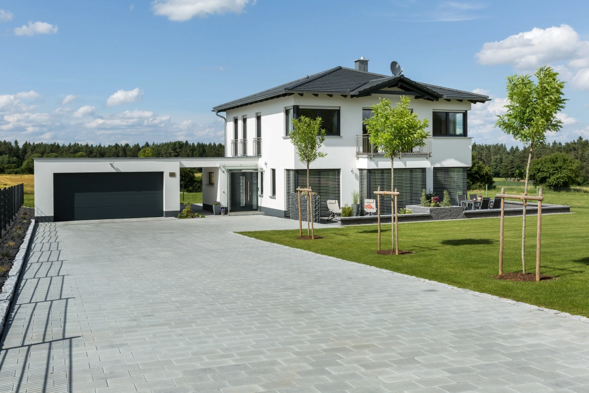 Modern house with large driveway and paving in a row bond 