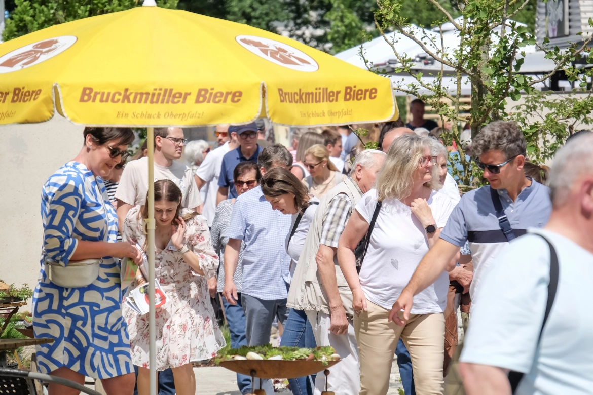 Der neu gestaltete Ideen-Garten präsentiert verschiedene Gestaltungsmöglichkeiten mit Betonsteinen, Pflanzen und Dekorationselementen, die Besucher flanieren durch die Ausstellung.
