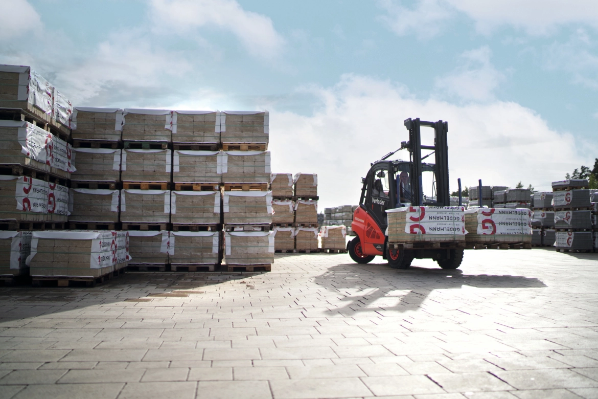 Forklift loaded with two stone packages moves in the warehouse.