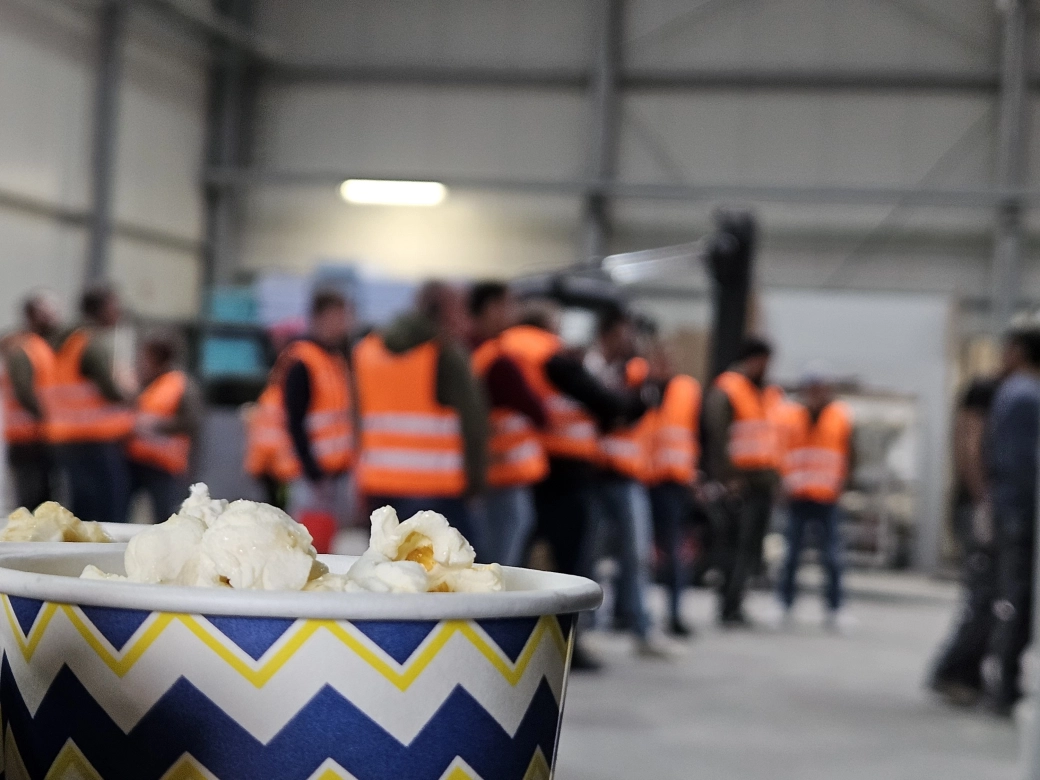 GODELMANN Kino: Popcorn im Vordergrund, Werksführungsteilnehmer im Hintergrund