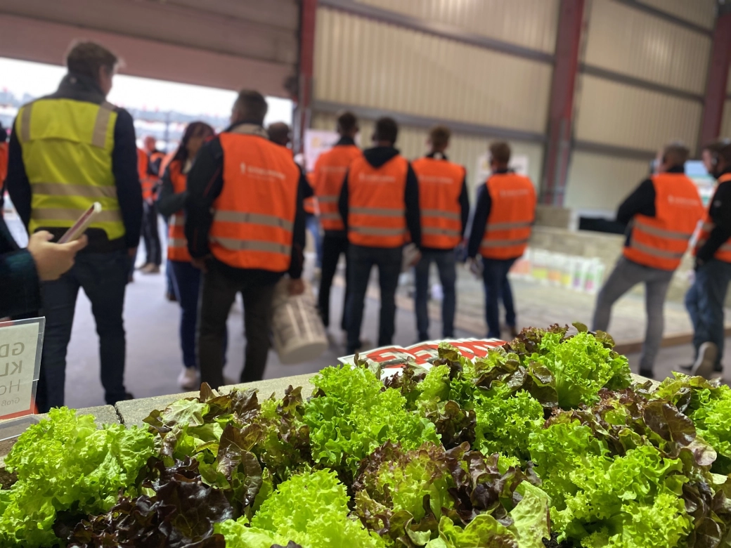 Werksführungsteilnehmer vor einem Beispielhaft aufgebauten Hochbeet aus GODELMANN Mauersteinen.