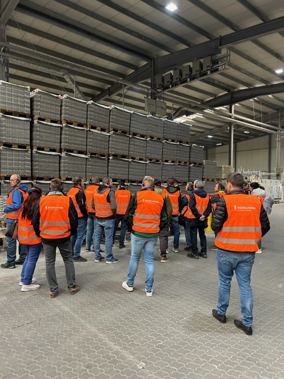 Werksführung: Guide erklärt einen Sachverhalt in einer Produktionshalle.