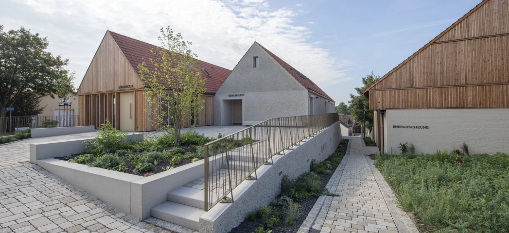 Modern buildings with timber and rendered façades, ecological paving and landscaped gardens.
