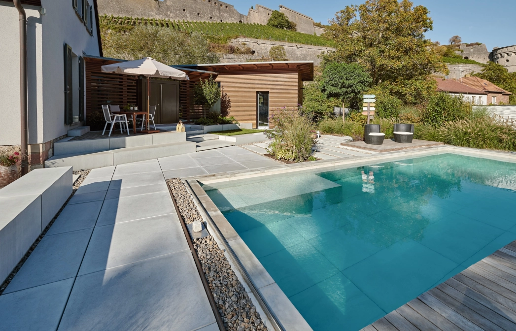 Moderner Garten mit großen pool und Terrasse mit großformatigen Terrassenplatten