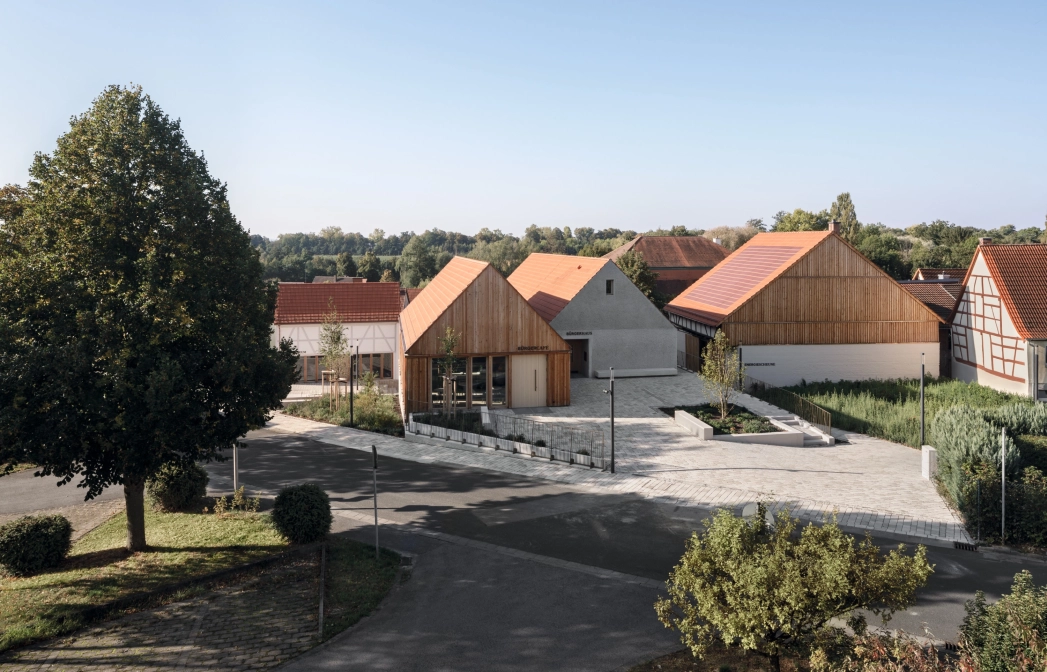 Residential area with modern and traditional houses, tree-lined streets and clear skies.
