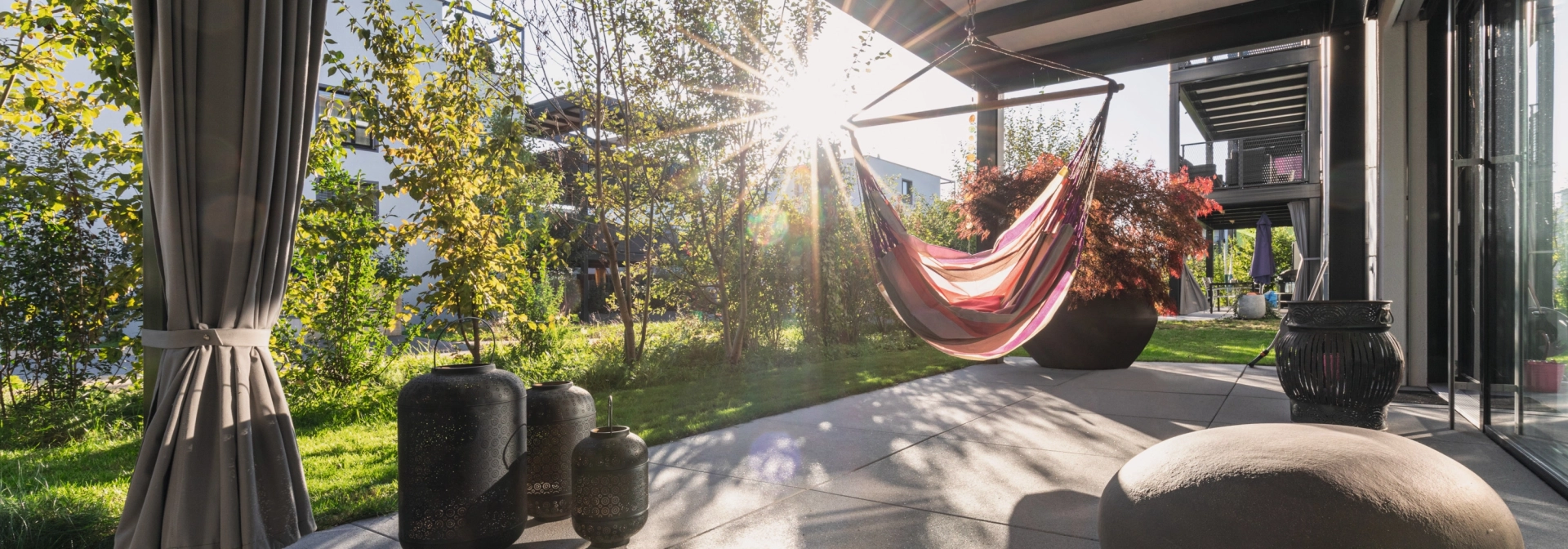 Sunny terrace with large slabs and hanging swing.
