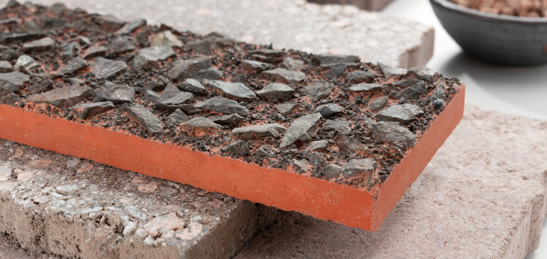 Handmade red concrete surface pattern with coarse stone inclusions
