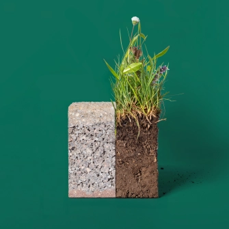A two-part climate stone, which consists of a three-layer, infiltration-capable concrete block on the left-hand side and soil with an associated meadow on the right-hand side.
