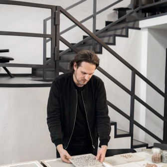 Sebastian Herkner in seinem Studio mit unterschiedlichen Farbmustern, die er überprüft.