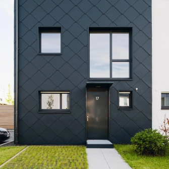 schwarzes Reihenhaus mit schmalen Eingangsbereich