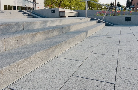 hellgrau gepflasterte Treppenanlage zum Eingang des Thermalbades mit Bäumen
