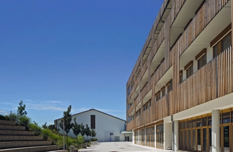 Realschulgebäude mit Holzfassade und Vorplatz mit modernem Pflaster