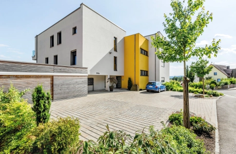 modern apartment building with planted driveway 