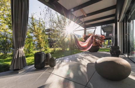 Sunny terrace with large slabs and hanging swing.