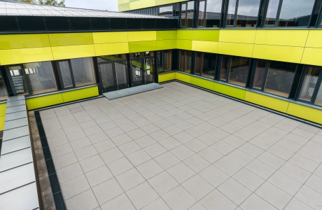 Schulhof einer neu Sanierten Mittelschule mit hellen, großformatigen Platten befestigt