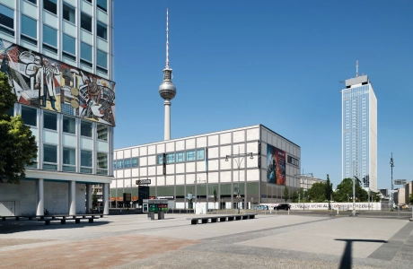 großer gepflasterter Platz vor Hochhaus mit roten und verschiedenen grauen Pflastersteinen