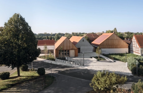 Residential area with modern and traditional houses, tree-lined streets and clear skies.