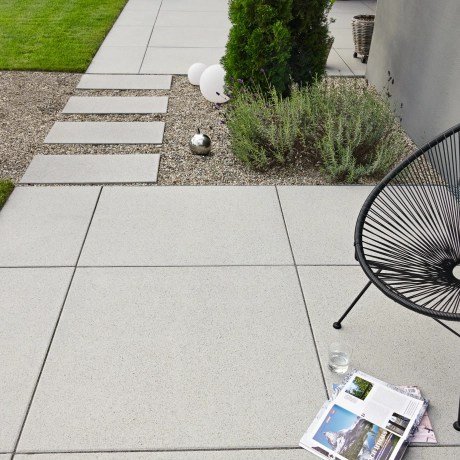 Private path around a detached house with large-format patio slabs.
