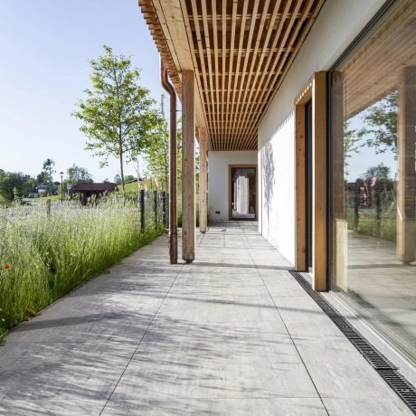 Large-format slabs as terrace paving in front of a green meadow.