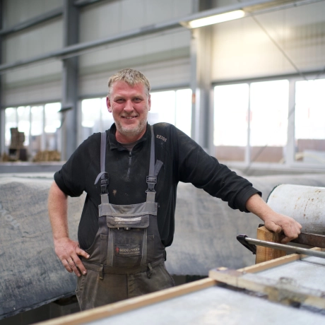 Mitarbeiter in der Beton-Manufaktur, der in der Kamera lächelt