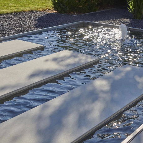 Massimo Platte als Weg über einen flachen Wasserbecken im Garten