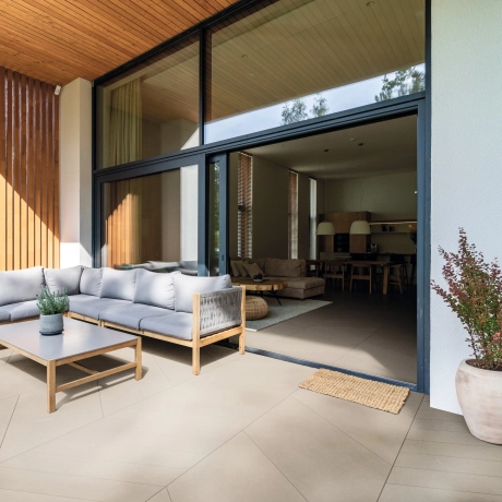 Offener Wohnbereich zur Terrasse mit Betonfliesen in Fischgrät-Optik