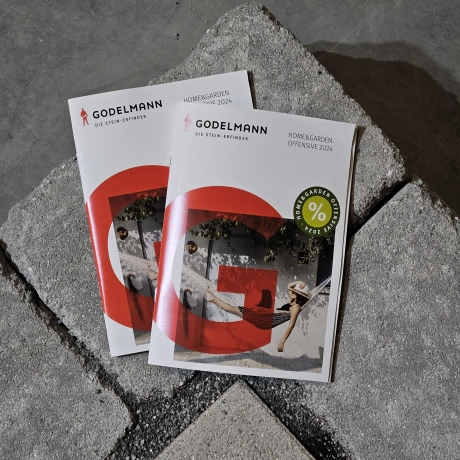 Zwei GODELMANN Flyer auf einer Mauer aus GODELMANN Mauersteinen.