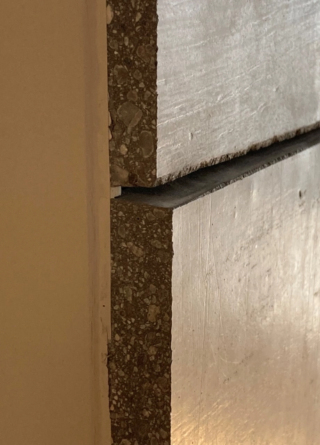 rillenartige Oberflächenstruktur der grauen Wandfließe mit seitlicher Ansicht auf die Körnungen und Struktur der Fließe