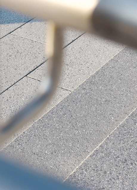 hellgraues Pflaster mit silbernen Treppengeländer