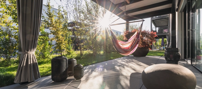 Sunny terrace with large slabs and hanging swing.