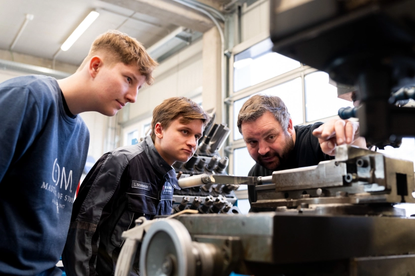 Azubis schauen ihren Ausbilder zu - Metallverarbeitung