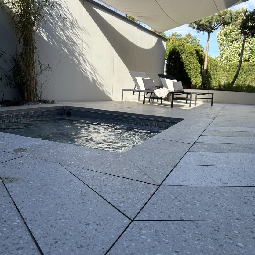 Small whirlpool set into the ground. Terrace covered with GDM.AWA tile