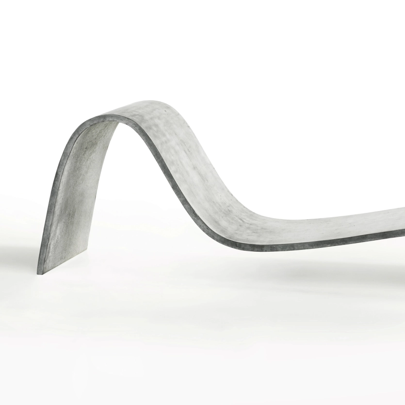 Edel geschwungene Betonliege Zephyr in klassischem Betongrau vor weißem Hintergrund