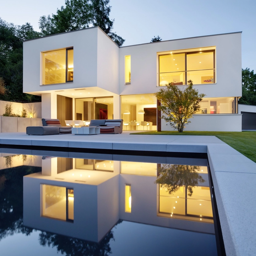 Winkelstufe NUEVA ferro Grau-Uni 120/40/15/5 cm und ein Pool vor einem modernen Haus
