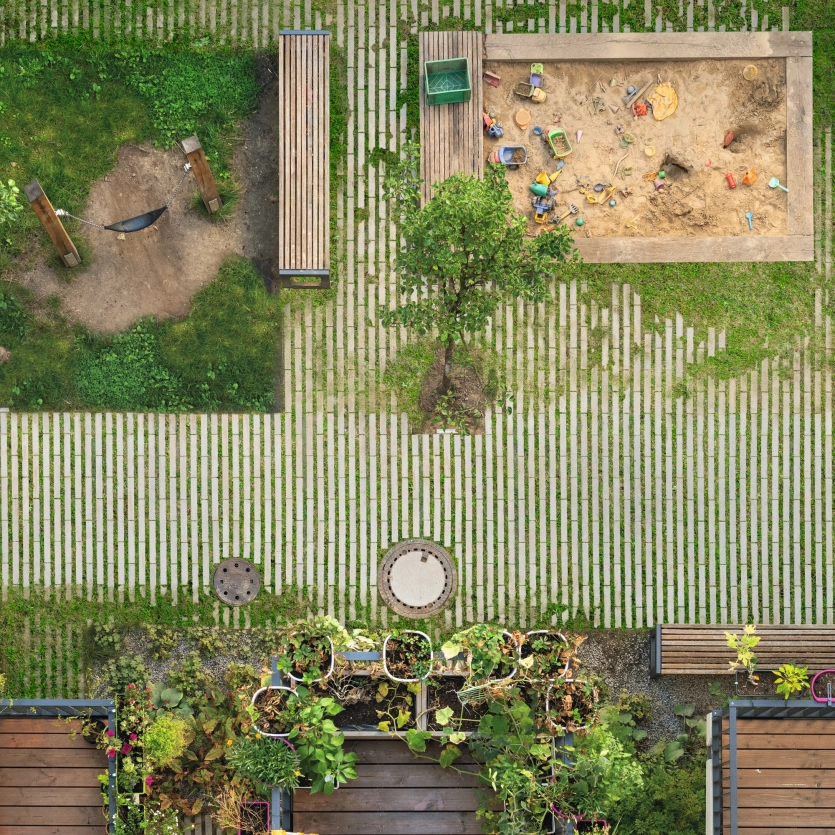 Luftaufnahme von einem Spielplatz mit Sandkasten und Schaukel und GDM.Scada Rasenliner mit begrünten Fugen