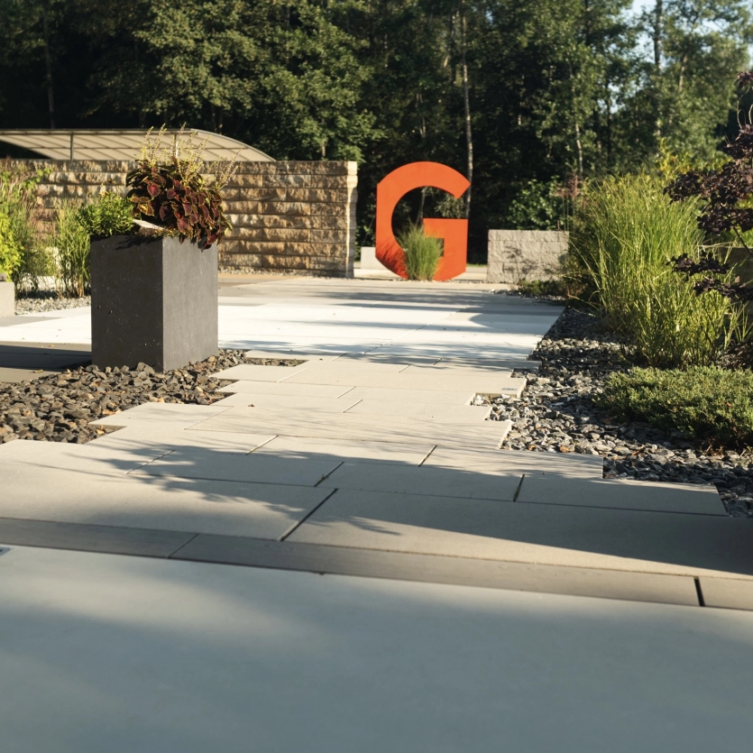Modern garden with patio slabs, a wall and a plant trough.
