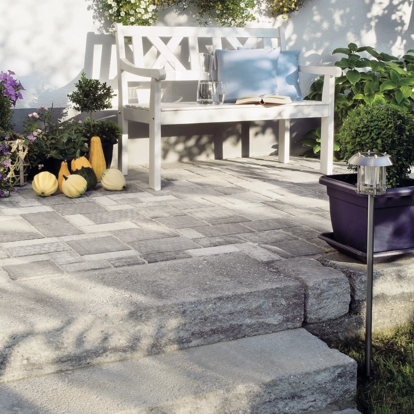 Grey-black colored paving with steps surrounded by decoration.