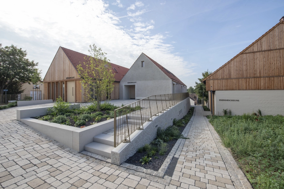 Modern buildings with timber and rendered façades, ecological paving and landscaped gardens.